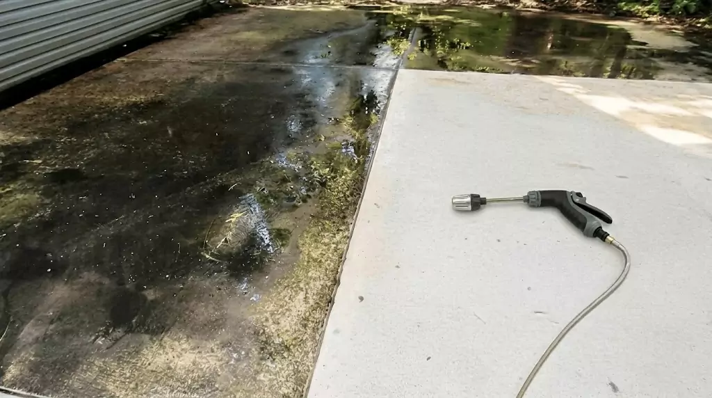 Power Blast test on a narrow concrete strip with years of algae buildup — clear cleaned line through the dirty area